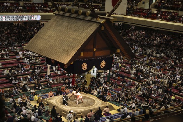 Sumo competition in the big Kokugikan with numerous spectators and traditional roof, Tokyo, Ryogoku, Japan