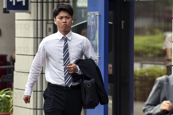 Businessman in a suit walks hurriedly down a street, Tokyo, Minato, Japan