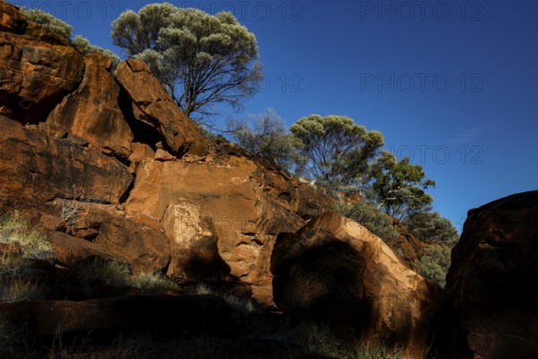 Massive rock formations with sparse vegetation and deep blue sky, Palm Valley, Northern Territory, Australia