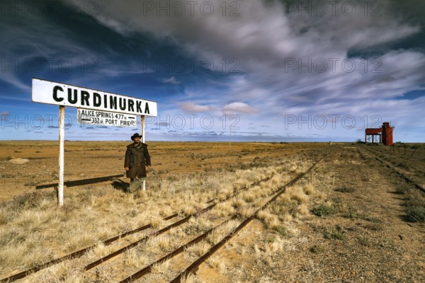 Abandoned station sign and water tower along a dusty track, Curdimurka, Oodnadatta Track, South Australia, Australia