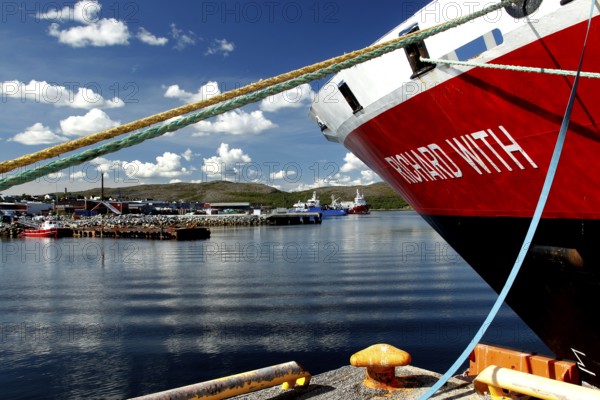 View of the bow of a Hurtigruten ship in the sunny port of Kirkenes, Kirkenes, Finnmark, Norway