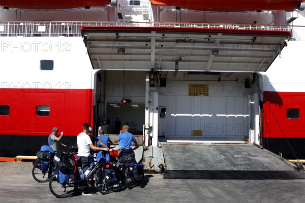 Cyclists prepare at the loading dock of a ship, Kirkenes, Finnmark, Norway