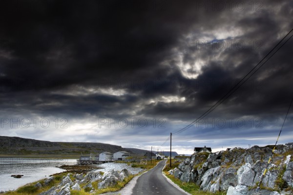 Country road runs along the coast under dramatic skies, N Hamningberg, zero