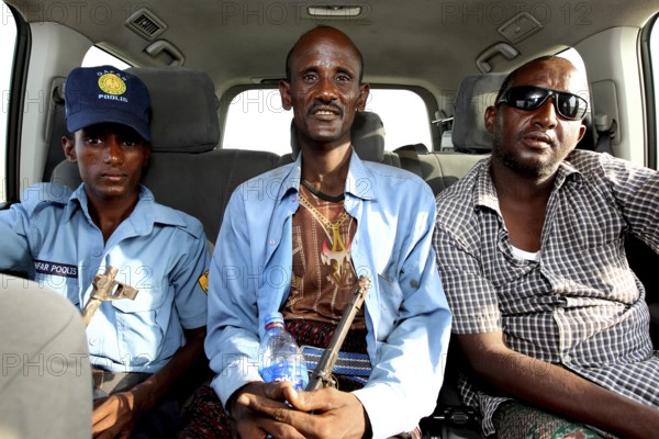Three people sit in a Landcruiser in Ahmedela while talking, Ahmedela, Ethiopia
