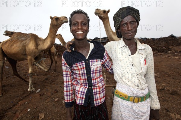 Camel driver with two camels in camp on Erta Ale, smiling at the camera, Erta Ale, Ethiopia