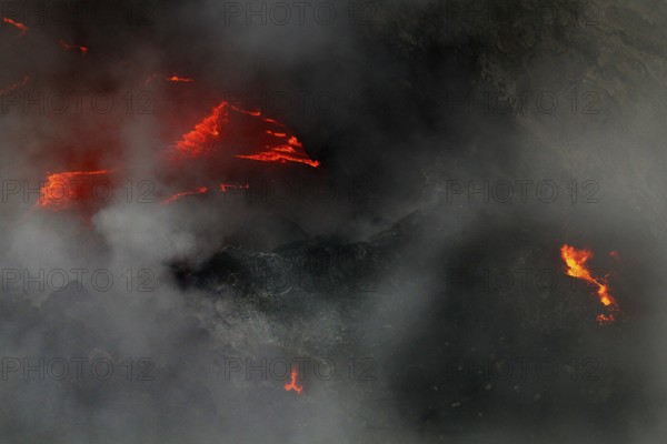 Glowing lava breaks through thick steam in the volcano, Erta Ale, Ethiopia
