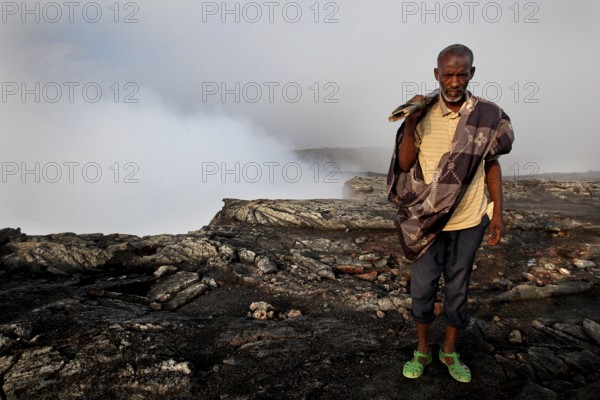 Police officer Muhammed at the edge of the smoking crater of Erta Ale, Erta Ale, Afar, Ethiopia