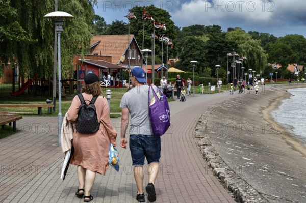 People stroll along the lagoon promenade in Nida on a sunny day, Nida, Curonian Spit, Lithuania