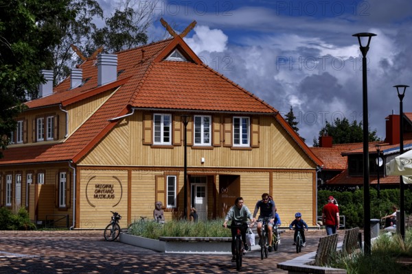 Traditional wooden house on the Curonian Spit with playing children and family, Nida, Curonian Spit, Lithuania