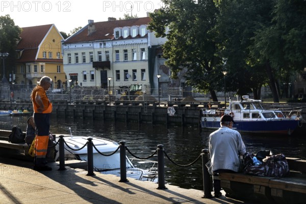 Anglers on the Dange in Klaipeda with a view of historic buildings and boats, Klaipeda, null, Lithuania