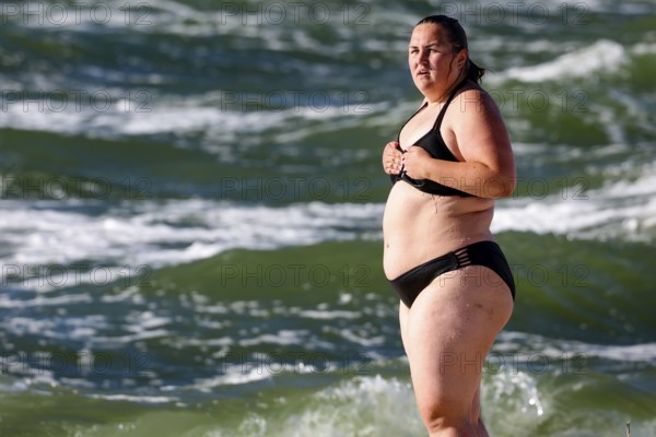 Woman in water on Nida beach surrounded by waves of a summer sea, Nida, null, Lithuania