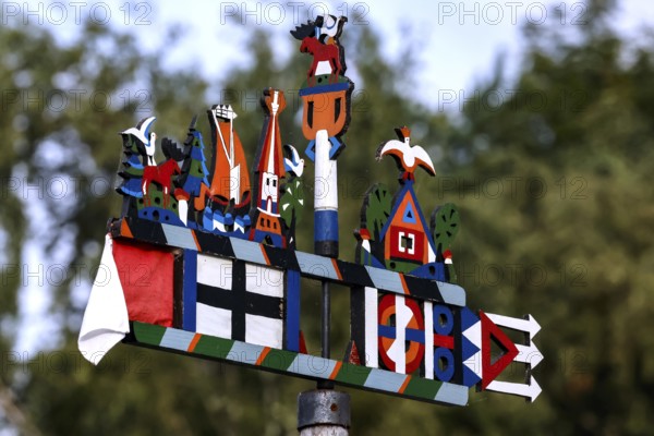 Colourful Kuren pennant with folk symbols in front of blurred trees, Juodkrante, Klaipeda, Lithuania