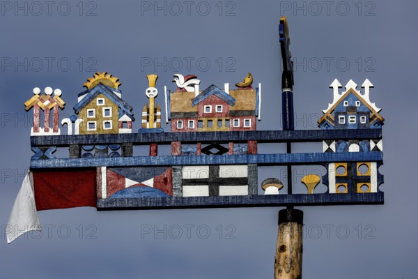 Colourful, traditional Kurenpennant with various symbols against a blue sky, Juodkrante, Klaipeda, Lithuania