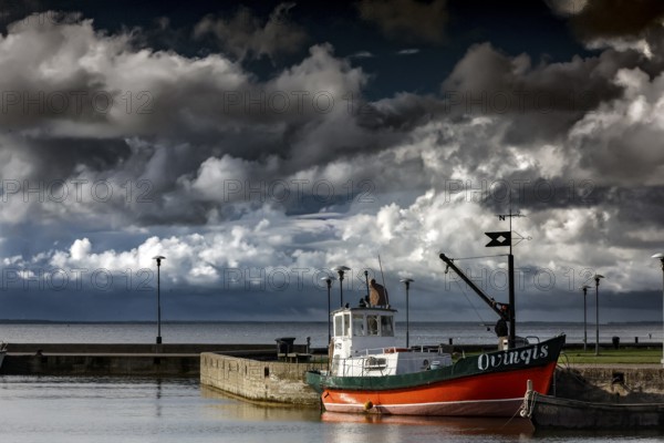 Fishing boat in Juodkrante harbour under dramatic sky, Juodkrante, Lithuania