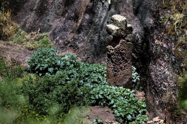 Cross in rocky surroundings surrounded by shrubs, symbolic representation in Lalibela, Lalibela, Amhara, Ethiopia
