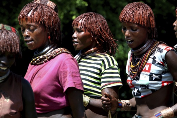 Hamer woman, wearing glowing clothes, dance as part of a festive initiation ceremony, Turmi, Ethiopia