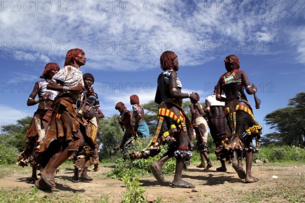 Energetic dance by Hamer woman in traditional surroundings as part of their initiation ceremony, Turmi, Ethiopia