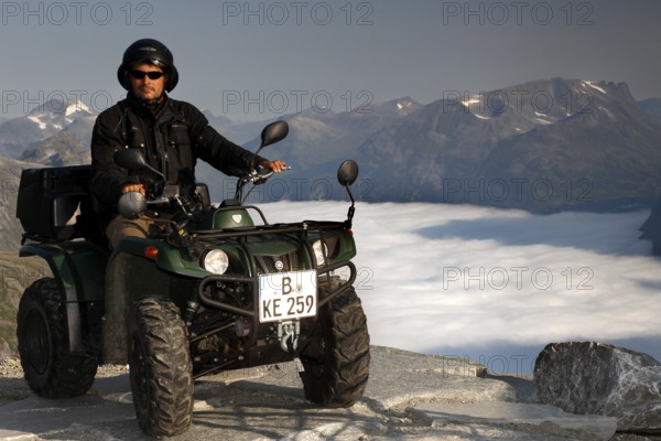 Person on ATV enjoying breathtaking views of Dalsnibba in Geirangerfjord, Dalsnibba, Geirangerfjord, Møre og Romsdal, Norway