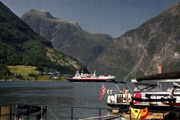 Hurtigruten ship in the fjord with surrounding mountains and water, Geirangerfjord, Norway