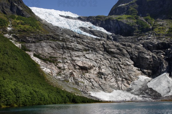 Spectacular Bøyabreen glacier tongue surrounded by steep rocks and green hills, Bøyabreen, Norway