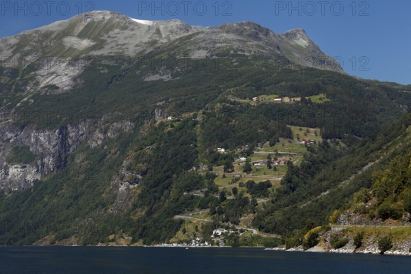Green mountain slopes with road and fjord views, Geirangerfjord, Norway