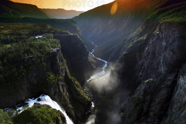 The Vøringsfossen Waterfall in Måbødal appears dramatically in the light of a magnificent sunset, Eidfjord, Norway