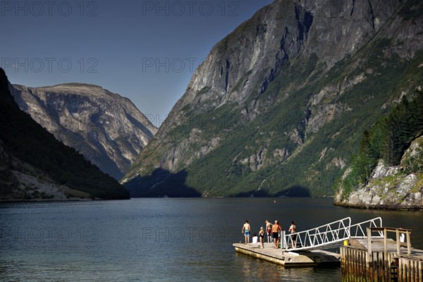 Wooden walkway rises into the quiet Nærøyfjord, surrounded by imposing mountains near Gudvangen