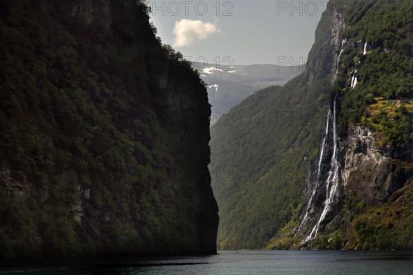Dramatic waterfall falling in Geirangerfjord surrounded by steep cliffs, Geirangerfjord, Møre og Romsdal, Norway