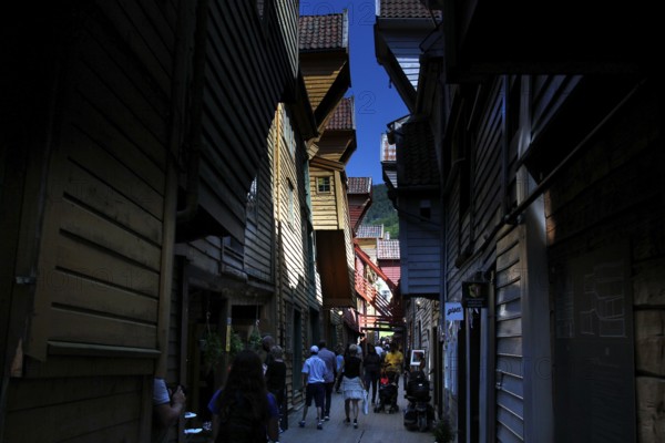 Shady wooden house alley in Tyskebryggen in sunny weather, Bergen, Hordaland, Norway