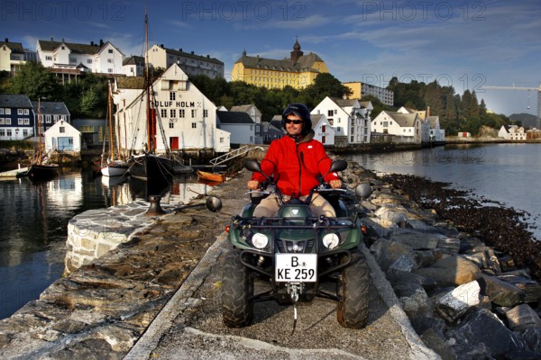 ATV rider on the dock in front of the fishing museum in Ålesund in sunny weather, Ålesund, Møre og Romsdal, Norway