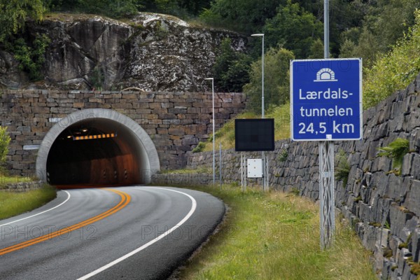 Entrance to the Lærdal Tunnel with road sign in mountainous surroundings, zero