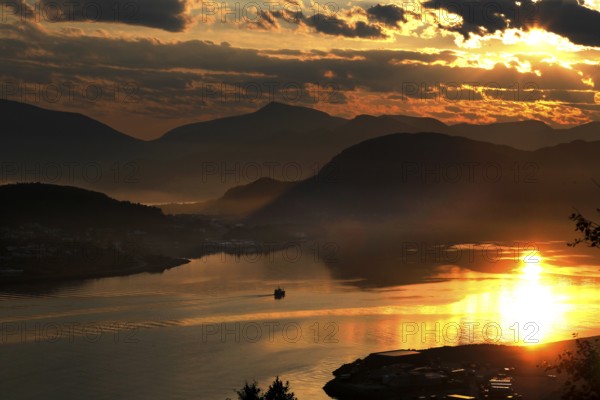 Impressive sunset with reflecting water from Kniven viewpoint in Ålesund, Ålesund, Norway