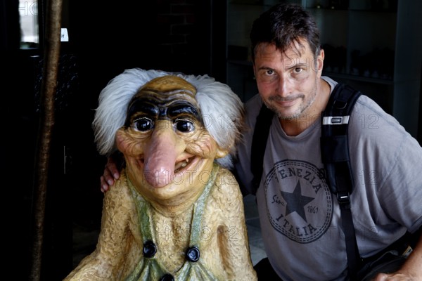 Man posing with troll figure in a souvenir shop in Bergen, Bergen, Vestland, Norway