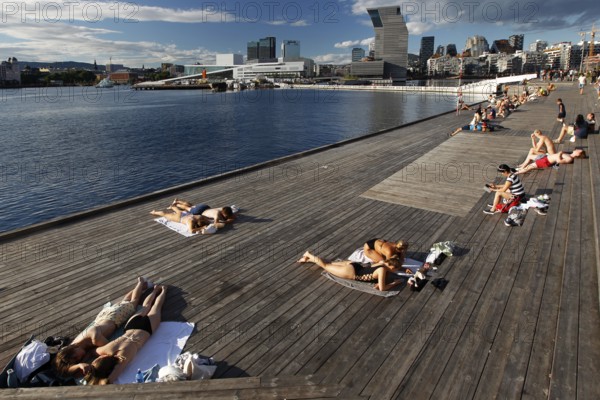 People sunbathe on a deck with a view of the Munch Museum in Oslo, Oslo, Bjøvika, Norway