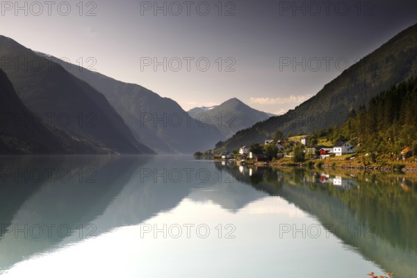 Reflection of mountains in the calm water of Fjærlandsfjord near Mundal, Mundal, Norway