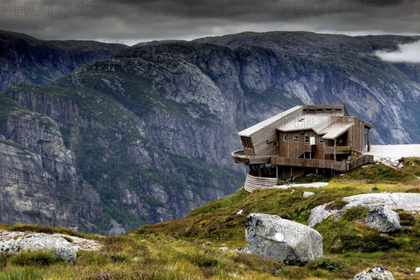 Panoramarestaurant Øygardstølen towers dramatically over the Lysefjord under a grey sky, Lysefjord, Rogaland, Norway