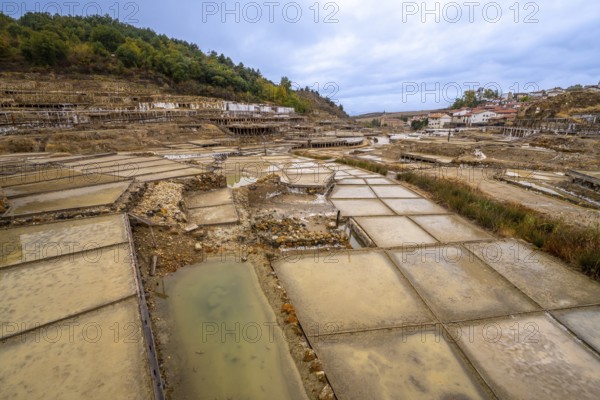 Ancient complex of salt flats and evaporation terraces for producing salt, forming a unique cultural landscape in anana, basque country, showcasing traditional methods of salt extraction