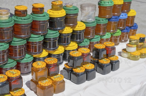 Lots of colorful honey jars with various lids on a market stand, near Gudauri, Mtskheta-Mtianeti region, Georgian Military Route, High Caucasus, Georgia