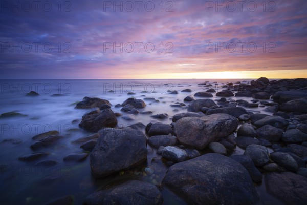 Rocky bay under a dramatic glowing sky at the coast. unset, Vigrestad, Rogaland, Norway