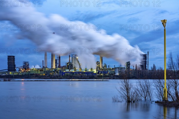 Rhine near Duisburg-Bruckhausen, industrial setting of the ThyssenKrupp steel plant, fire cloud of the Schwelgern coking plant, North Rhine-Westphalia, Germany