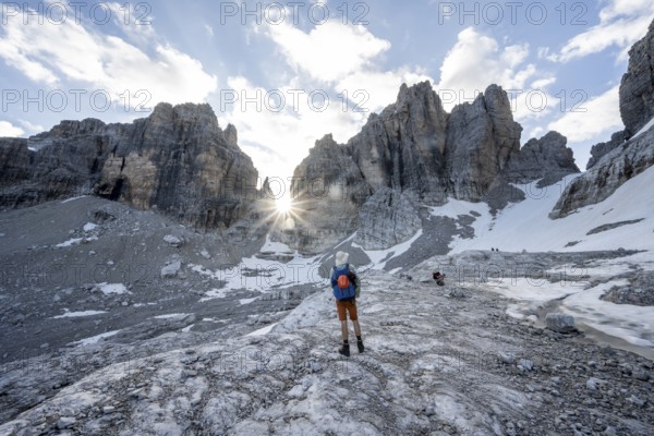 Mountaineers climbing a rocky mountain landscape with steep rock peaks to Bocca degli Armi, Sun Star, Brenta Mountains, Brenta-Adamello Natural Park, Trentino, Italy