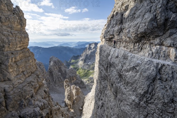 View from the Bocca degli Armi gap, mountaineers on a rock band on the Via Ferrata Bocciere Centrale via ferrata, Brenta Mountains, Brenta-Adamello Natural Park, Trentino, Italy