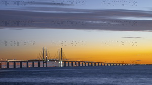 Modern Øresund bridge across the sea at sunset with colorful sky illuminated by a colorful sunset, Malmö, Skane län, Sweden