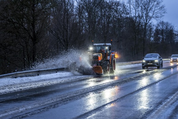 Winter service, spreader and snow plough in use, clears snow and slush from a regional road, Bergisches Land, near Marienheide, North Rhine-Westphalia, Germany