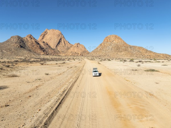 Aerial view, car on sandy road, mountains in the desert, Spitzkoppe summit, Namib desert, Namibia