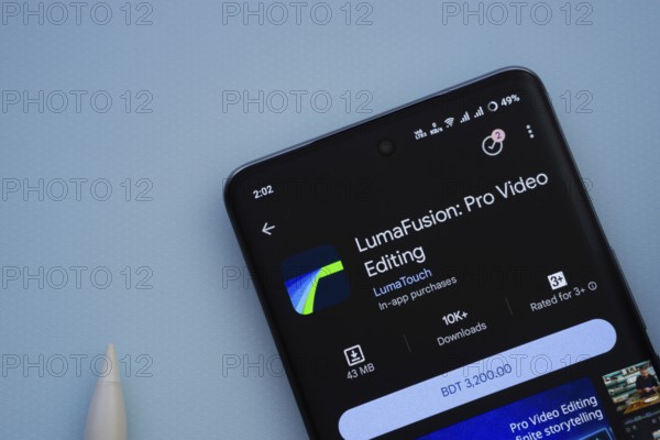 Dhaka, Bangladesh- 29 May 2025: On a blue surface, a smartphone displays the LumaFusion app within the Google Play Store