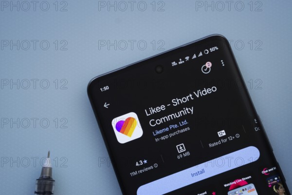 Dhaka, Bangladesh- 29 May 2025: On a blue surface, a smartphone displays the Likee app within the Google Play Store