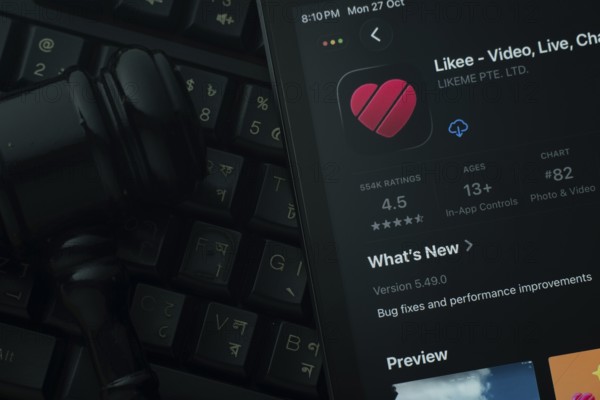 Dhaka, Bangladesh- 28 Oct 2025: An iPad displaying the Likee app against a judge's gavel and dark keyboard background