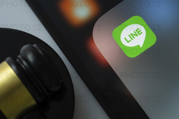 Dhaka, Bangladesh- 17 March 2025: A close up of an iPad screen displaying the LINE app alongside a judge's gavel