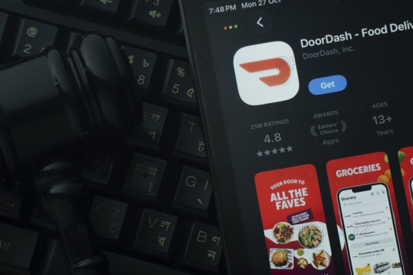 Dhaka, Bangladesh- 28 Oct 2025: An iPad displaying the DoorDash app against a judge's gavel and dark keyboard background